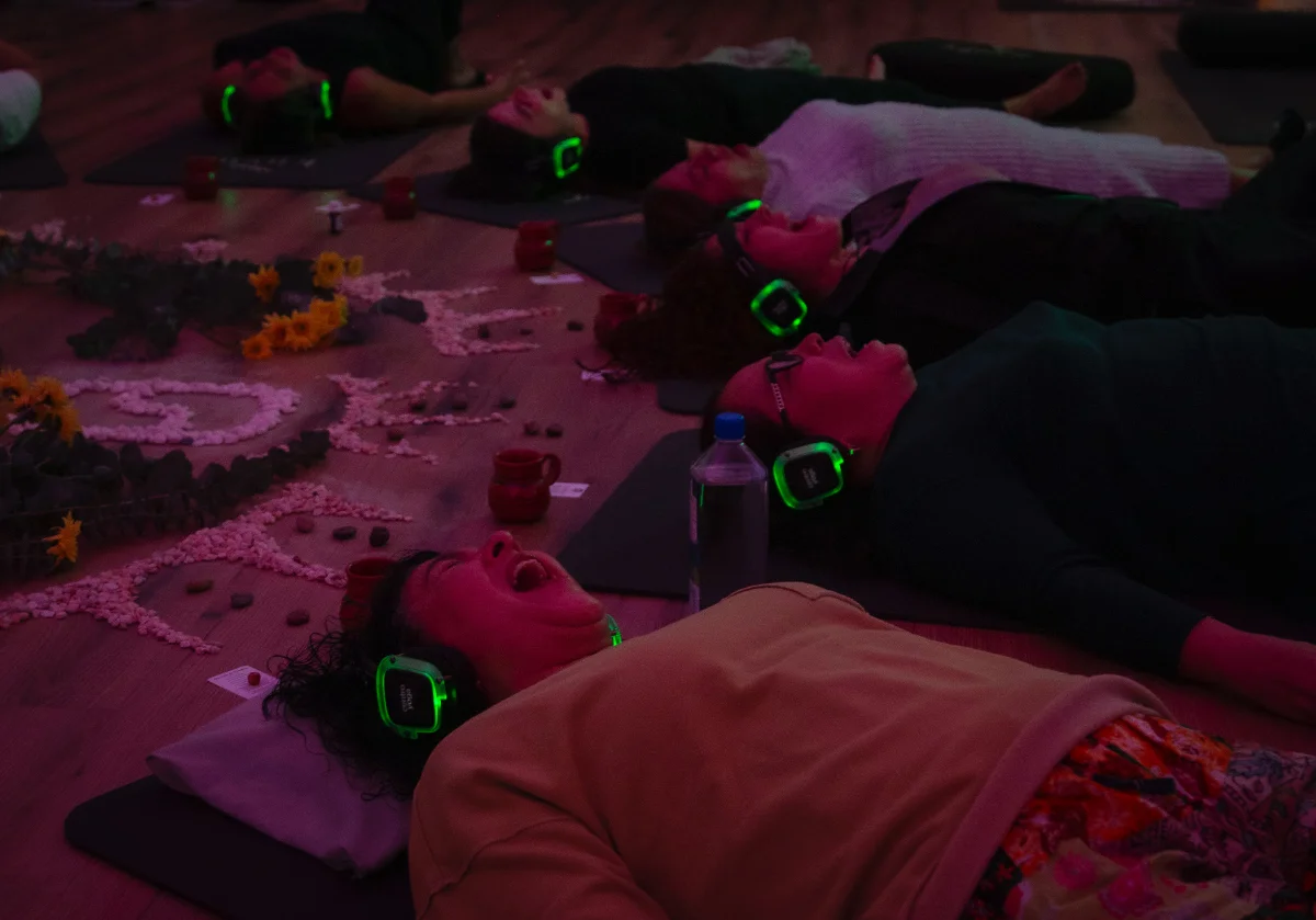 Foto: sesión de breathwork, luz cálida, manos sobre el pecho